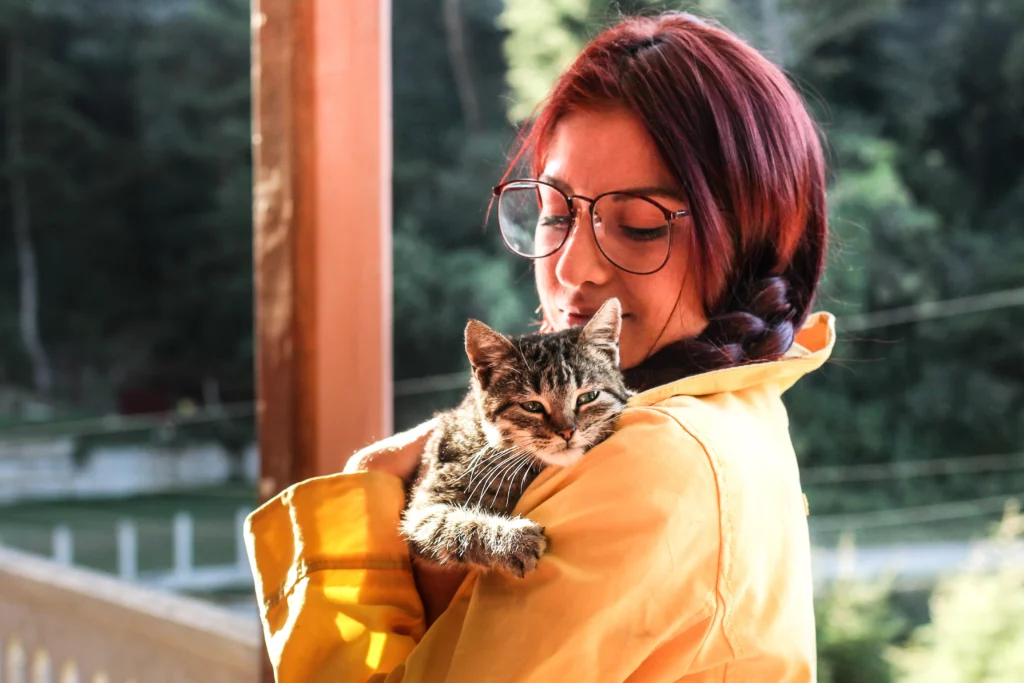 An ESA owner holding her emotional support cat on the porch of their rental apartment.