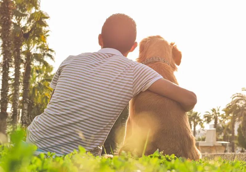 Man with his emotional support dog outside in the park