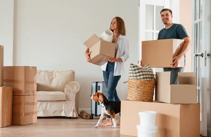 A couple and their dog moving in to a new apartment.